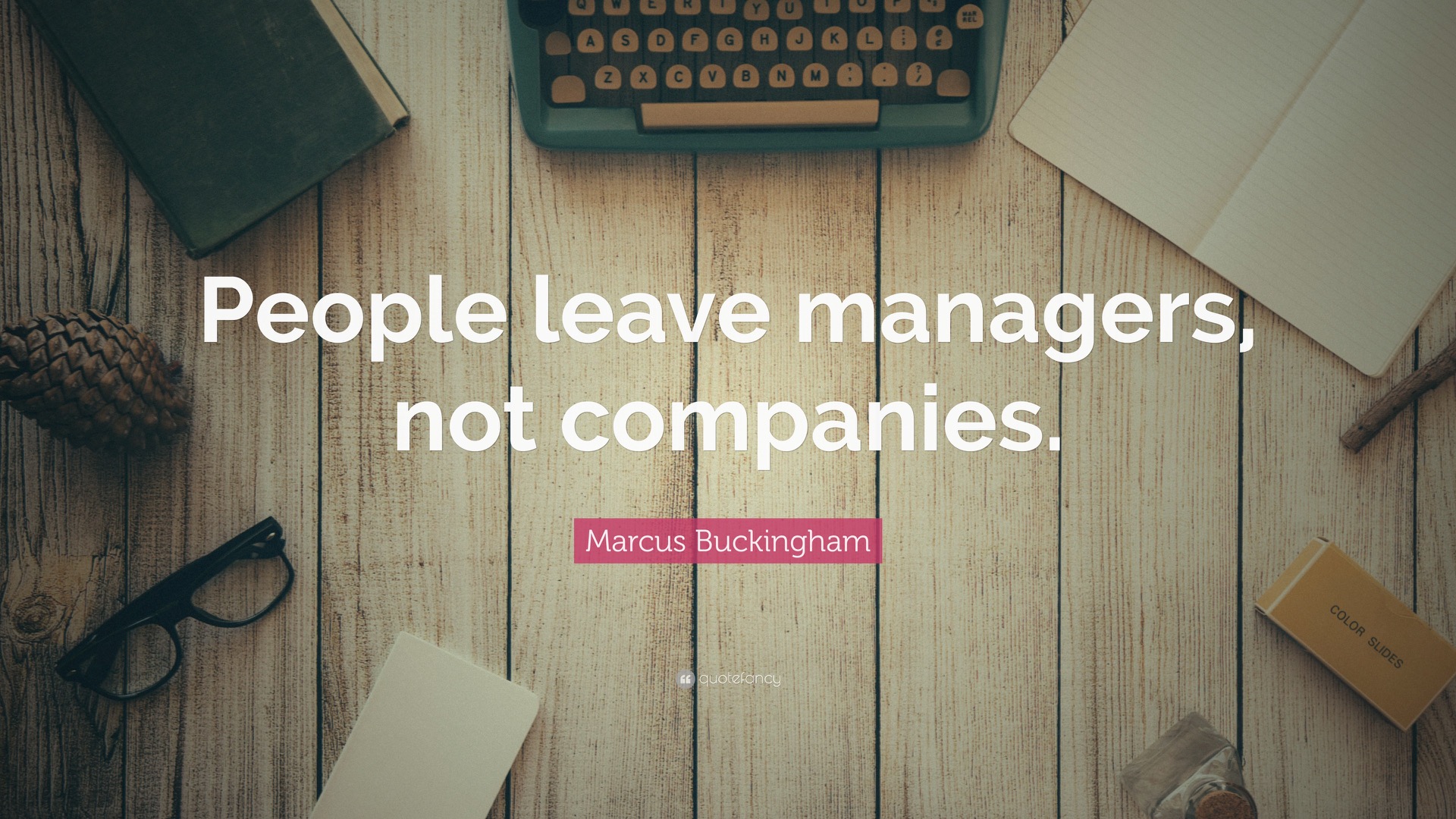 Overhead desk scene with keyboard, notebook, glasses, and quote text: People leave managers, not companies. image provided courtesy of https://quotefancy.com/quote/1510211/Marcus-Buckingham-People-leave-managers-not-companies